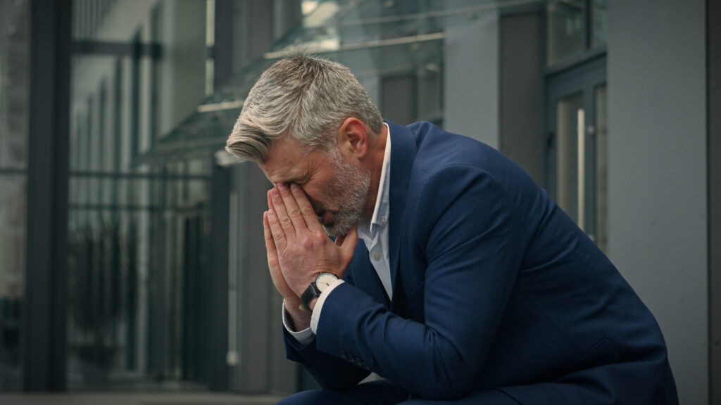 stressed man sat with face in hands