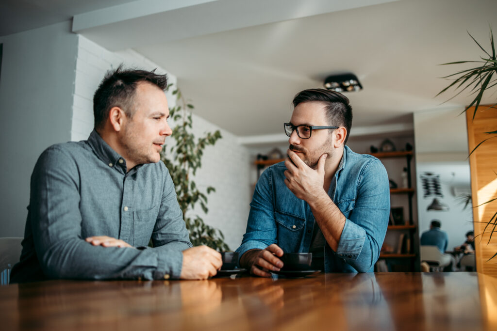 two men talking one stressed and worried