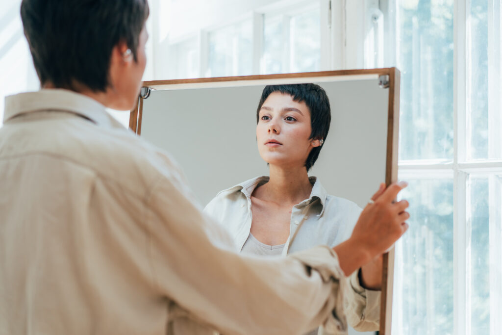 woman looking at herself in the mirror asking herself if she is a narcissist