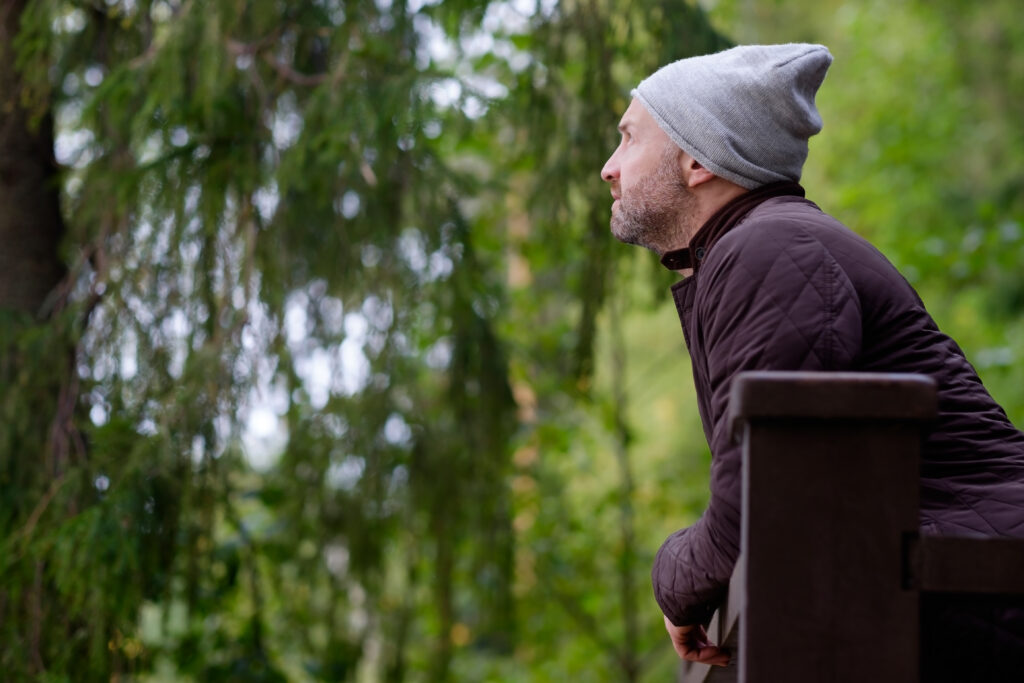 middle aged man looking off bridge reflecting