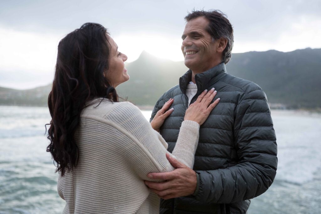 husband and wife embracing on a beach