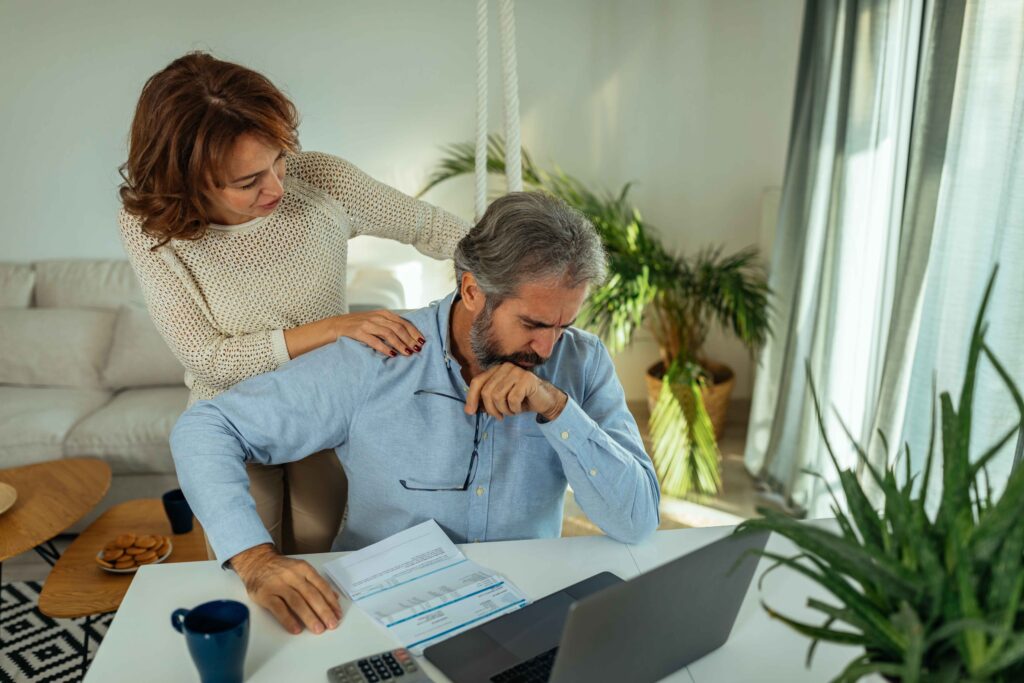 wife supporting man working on laptop