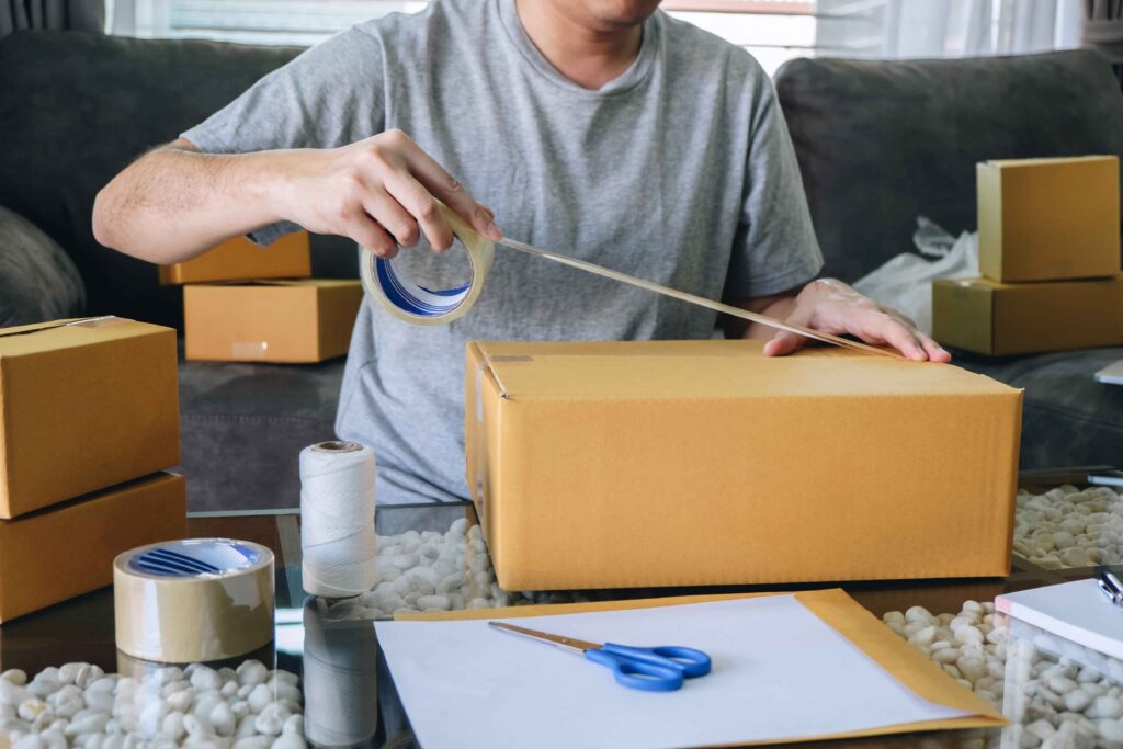 man packing a parcel he sold on eBay as his side hustle idea